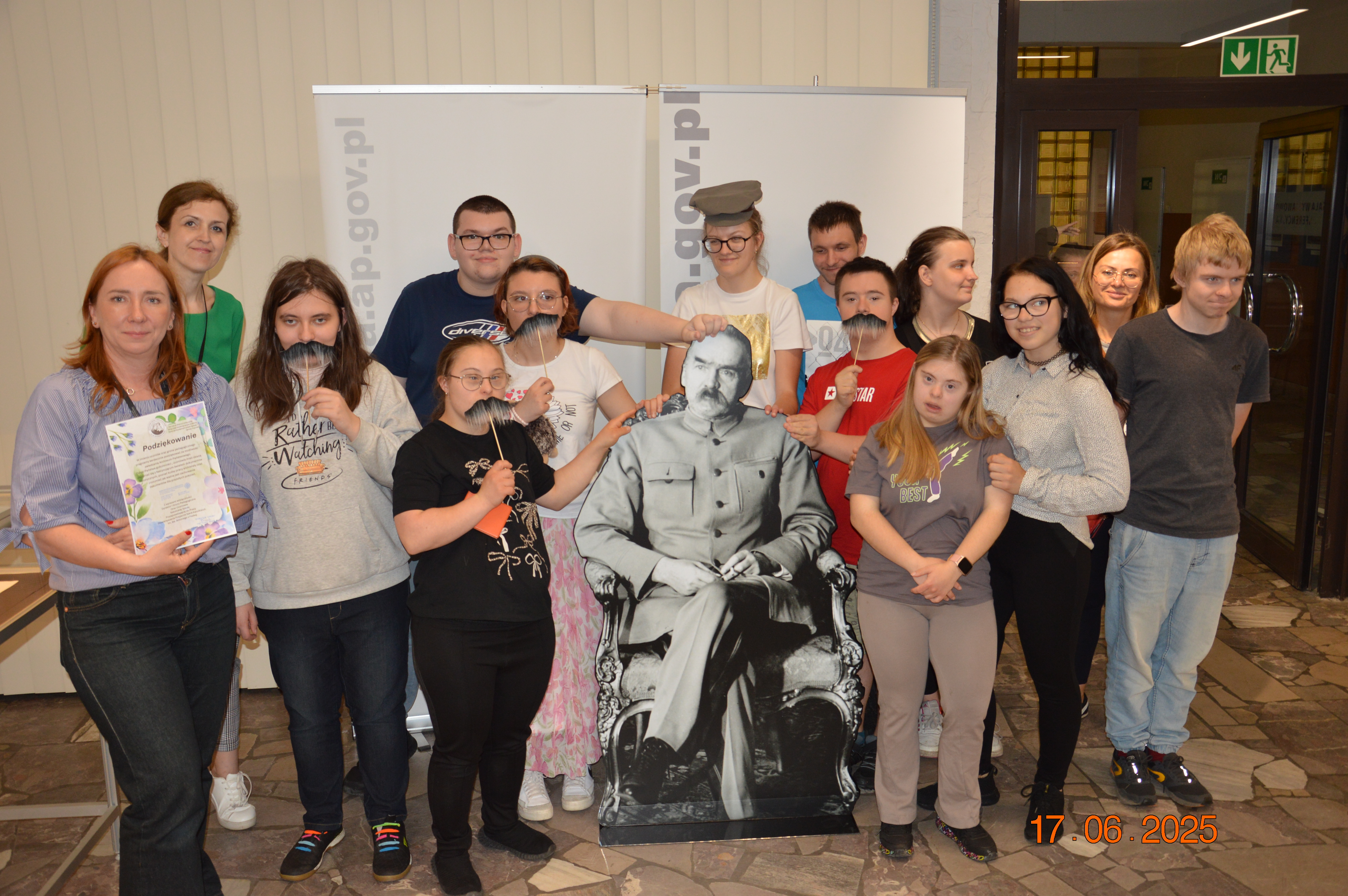 Grupka młodzieży przy makiecie Józefa Piłsudskiego