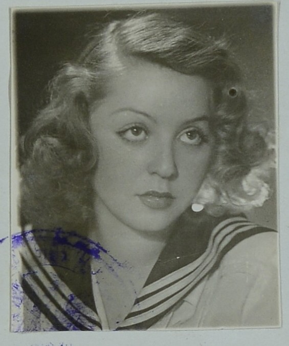 Młoda kobieta o jasnych, kręconych włosach, w koszuli z marynarskim kołnierzem